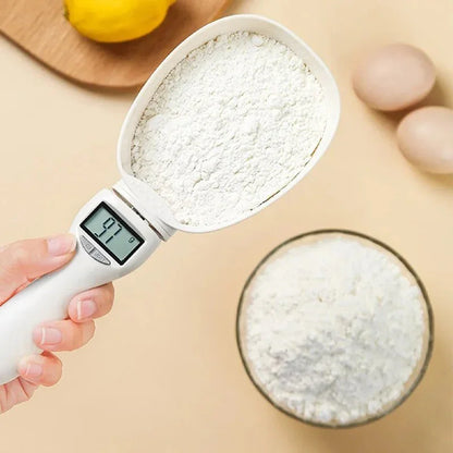 Digital measuring cup filled with flour,  with a bowl of flour and eggs in the background.